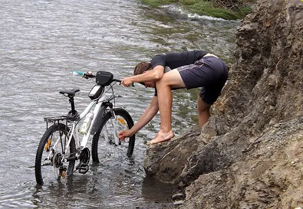 das Fahrrad am Fluss waschen